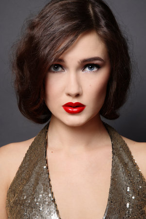 Close-up portrait of beautiful girl in sparkly dress with classical glamorous makeup