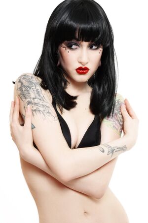 y young brunette with tattoos looking to the side thoughtfullyの写真素材