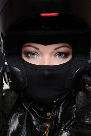 Portrait of beautiful woman with stylish makeup in black biker helmet, mask and glovesの写真素材