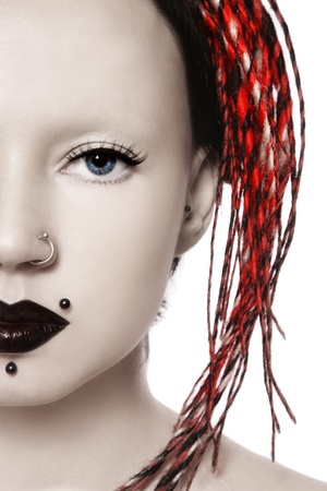 Close-up portrait of young freaky girl with shaved head, dreads and piercingの写真素材