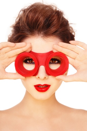 Yong beautiful girl with stylish make-up and old-fashioned red swimming goggles, on white backgroundの写真素材