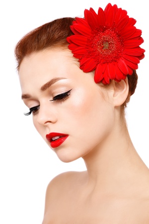 Portrait of young beautiful woman with stylish make-up and red gerbera on white backgroundの写真素材
