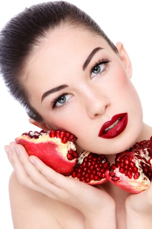 Portrait of young beautiful woman with pomegranates in her hands, on white backgroundの写真素材