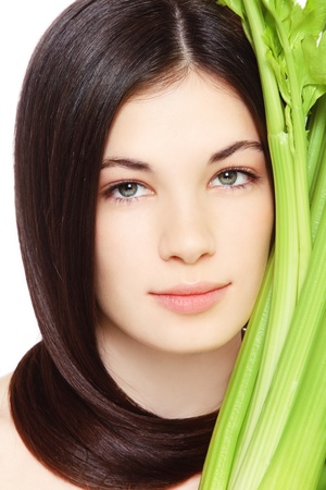 Portrait of young fresh beautiful healthy woman with clear make-up and green celeryの写真素材
