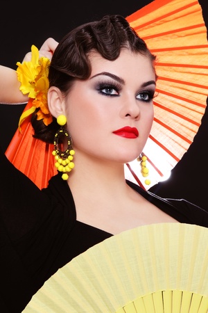 Beautiful stylish girl in flamenco costume with two colorful fansの写真素材