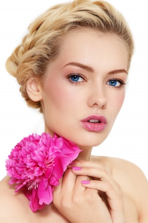 Young beautiful healthy blond girl with pink flower on white backgroundの写真素材