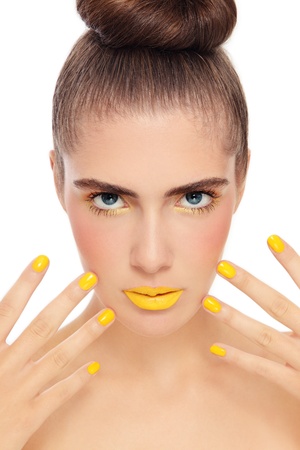 Young beautiful woman with fancy yellow manicure and make-up, on white backgroundの写真素材