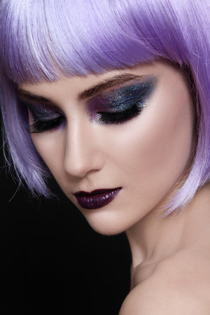 Portrait of young beautiful woman with violet wig and sparkly make-upの写真素材