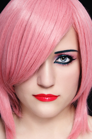 Close-up portrait of young beautiful woman in pink wigの写真素材