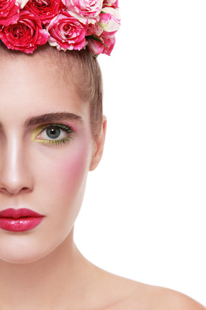 Close-up portrait of young beautiful woman with flower headband on her head over white backgroundの写真素材