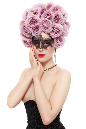 Portrait of young beautiful woman with fancy flower wig and venetian mask over white の写真素材