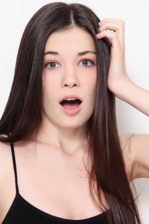 Young beautiful teen girl with long hair and scared expressionの写真素材