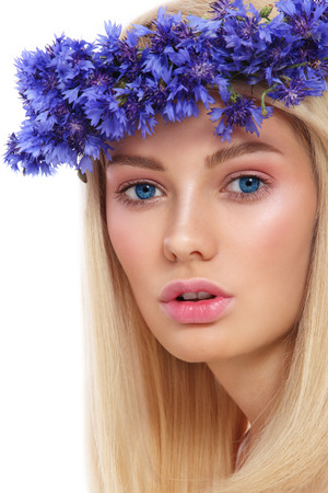 Young beautiful fresh girl with wreath of blue cornflowers on her head over white backgroundの写真素材