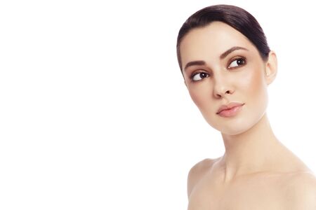 Portrait of young beautiful woman looking upwards over white backgroundの写真素材