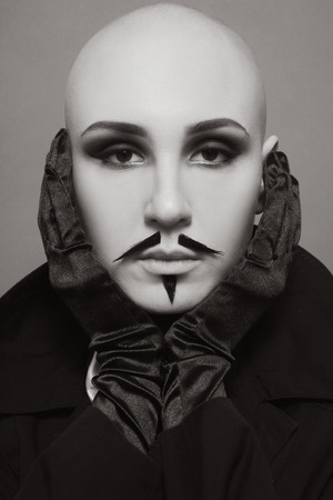 Sepia vintage portrait of skinhead woman with false whiskers and imperial beardの写真素材
