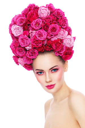 Young beautiful woman with stylish make-up in fancy vintage style wig of pink roses over white backgroundの写真素材