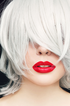 Close-up portrait of young woman with red lipstick and manga haircutの写真素材