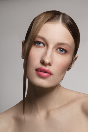 Portrait of young beautiful woman with clean make-up and fancy hairdoの写真素材