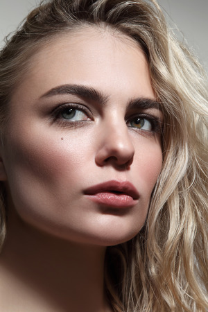 Close-up portrait of young beautiful woman with blond messy hairの写真素材