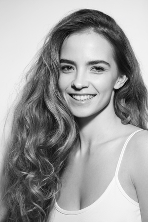 Black and white portrait of young beautiful happy smiling girl with long messy curly hairの写真素材