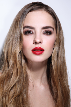 Young beautiful girl with long curly hair and red lipstickの写真素材