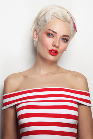 Vintage style portrait of young beautiful blond woman in striped topの写真素材