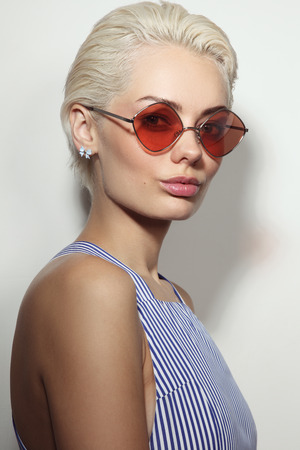 Vintage style portrait of young beautiful woman with stylish sunglassesの写真素材
