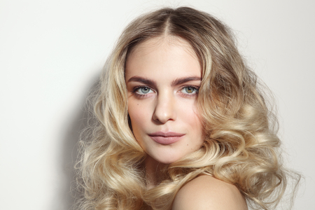 Young beautiful blonde woman with long curly hairの写真素材