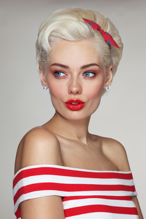 Vintage style portrait of young beautiful blond woman in striped topの写真素材