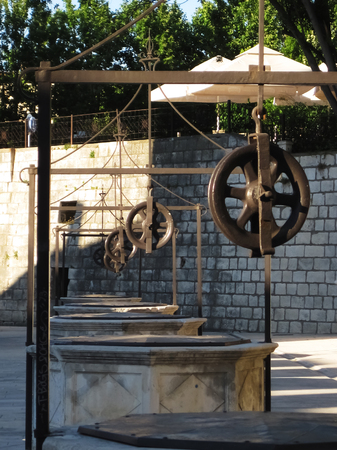Ancient, five wells with steel coil of stone in the old town of Zadar during the summerの写真素材