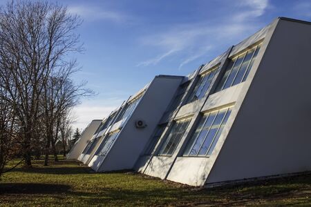 White,aluminum building with slope windows at sunset in autumnのeditorial素材