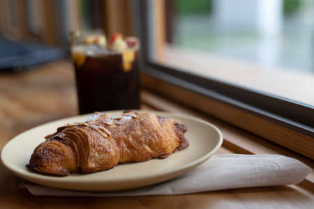 Croissant on plate with cold brew coffeeの写真素材
