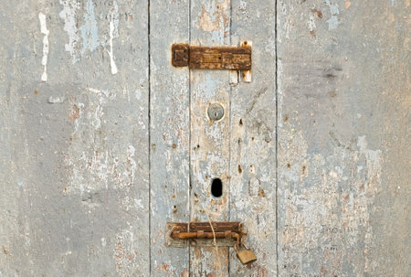 an aged wooden door, with rusty locks that suggests times gone byの写真素材