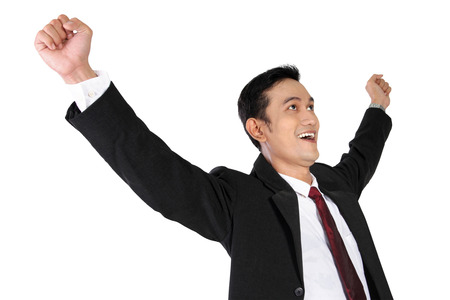 Young successful Asian businessman in suit and tie expressing happiness isolated on white backgroundの写真素材