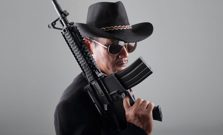 An old gangster and his machine gun, over grey background