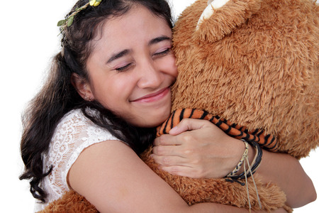 Happy sweet Asian girl hugging her big bear doll so tightly, over white backgroundの写真素材