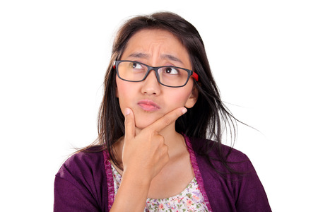 Headshot portrait of thoughtful Asian woman looking up in confusion, isolated on white background