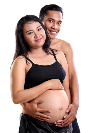 Joyful Asian couple expecting their first born child, posing to camera, isolated on white backgroundの写真素材