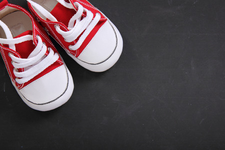 Red canvas shoes on top left composition of blackboard background with copy spaceの写真素材