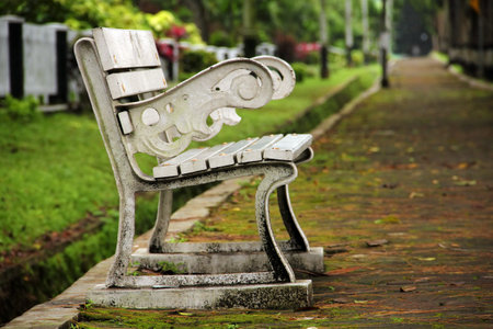 An old rusty bench on a sidewalk