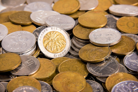 Old Rp 1000 on a pile of many others Indonesian rupiah coins money close up shotの写真素材