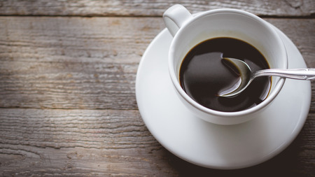 Morning Light Chill and Relax with Close  up Hot Coffee Cup on old  wooden in vintage color tone, used for food ad or website promote. beverage for people to work placeの写真素材