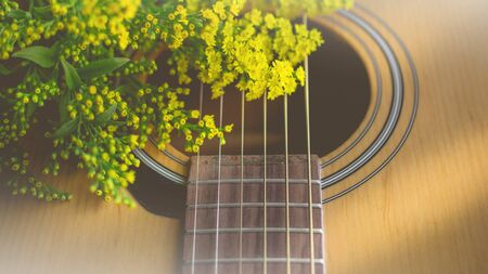 Morning relaxation and cozy with small yellow flower on guitar in vintage tone  for Rural vacation lifestyle , music therapy conceptの写真素材