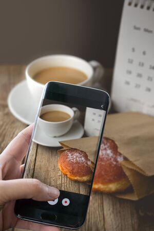 Photographing Hot Coffee and Donut on wood Background used for food ad or website promote. Snacks for people to work in the rush hourの写真素材