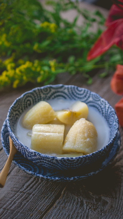 Thai banana in coconut milk with morning light on wooden background and copy space, Traditional  conservative secret recipe heritageの写真素材