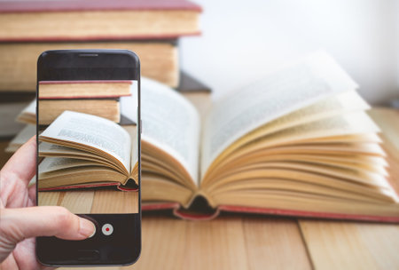 Taking a photo by Finger Pressing on Smartphone for Photograph Open book with copy space. Image for...
