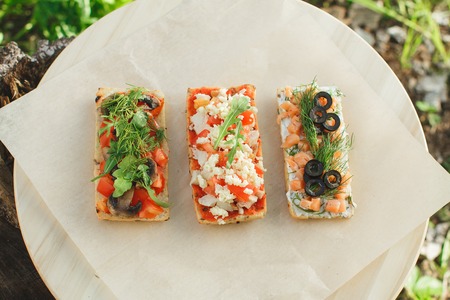 Italian tomato and cheese bruschetta. Tapas, antipasti with chopped vegetables, herbs and oil on grilled ciabatta and baguette bread.の写真素材