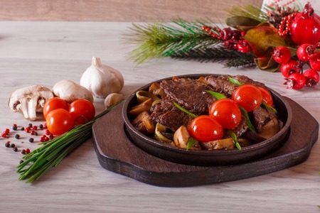 Grilled chicken fillets, chili pepper and tomatoes cherry on grill iron pan, fresh herbs - rosemary and parsley, rustic cutlery on gray slate background. top view. copy spaceの写真素材