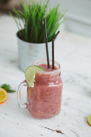 Three portions of different smoothies in a glass jar on a rustic wooden background.の写真素材