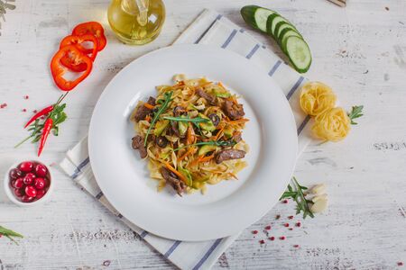 Spaghetti with Vegetables, Ham, Black Olives, Rucola and Pesto Sauceの写真素材